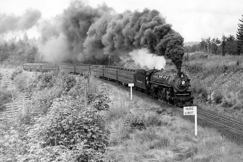 Steam locomotive smoking with passenger train on curve