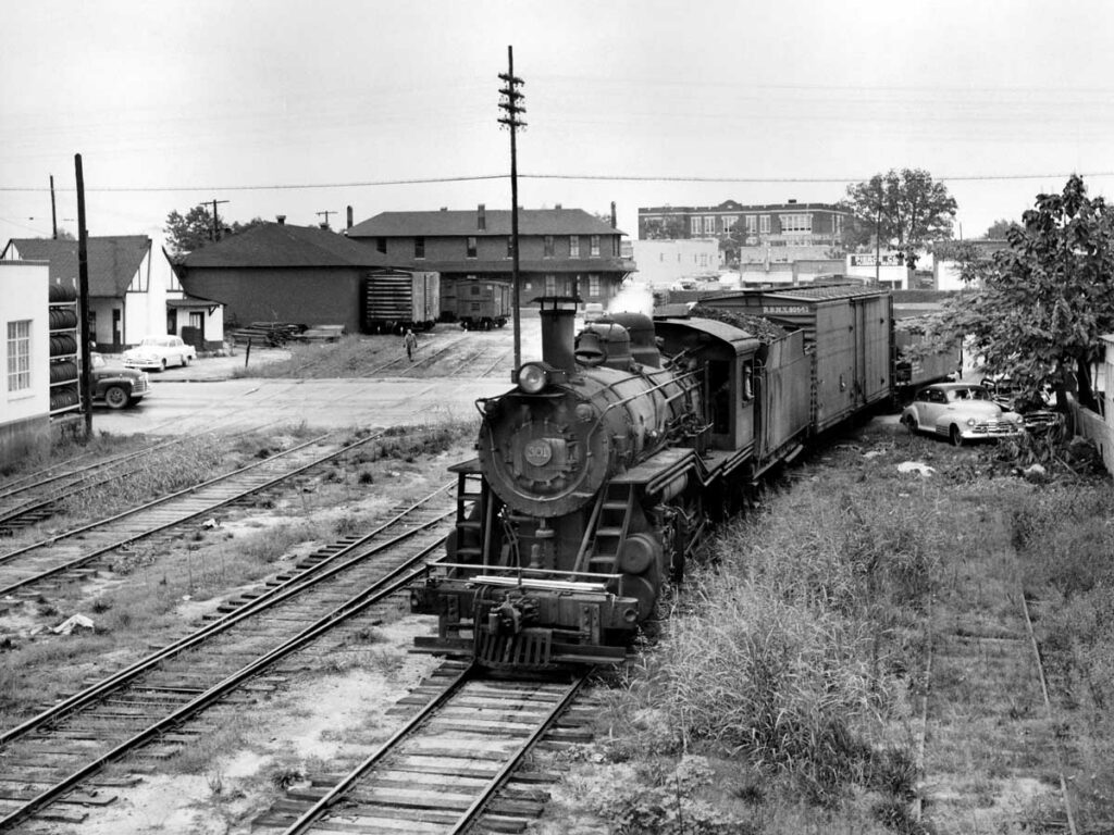 Steam locomotive with train on curve by brick station