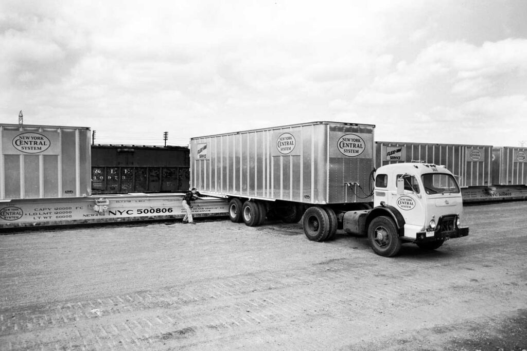 Semi truck backs onto railroad flatcar