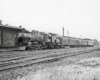 Steam locomotive with short passenger train at station