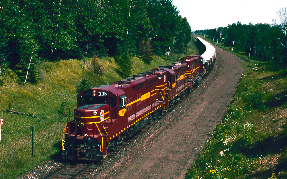 Three road-switcher diesel locomotives with freight train