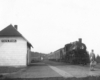 Steam locomotive with short passenger train at station