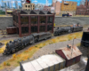 High-angle view of Santa Fe 2-10-2 and 4-8-4 facing left with sand house in foreground and brick car shup in background