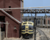 A blue-and-yellow Santa Fe EMD F3 diesel sits alongside a wooden sand bin