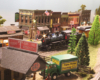 A well-preserved but old-fashioned steam locomotive pulls a combine into a small town