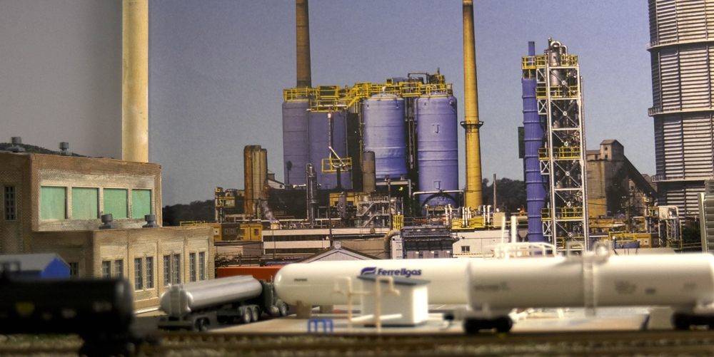 Long shot of an industrial scene with trains parked in front of buildings