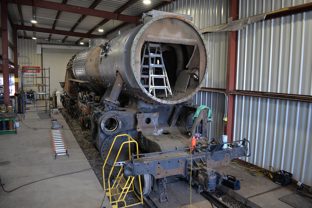 Steam engine being worked on in shop building