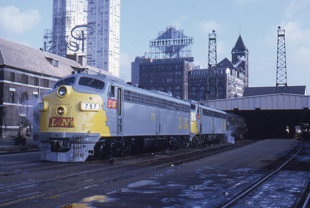 Gray and yellow locomotives on passenger train waiting to leave station