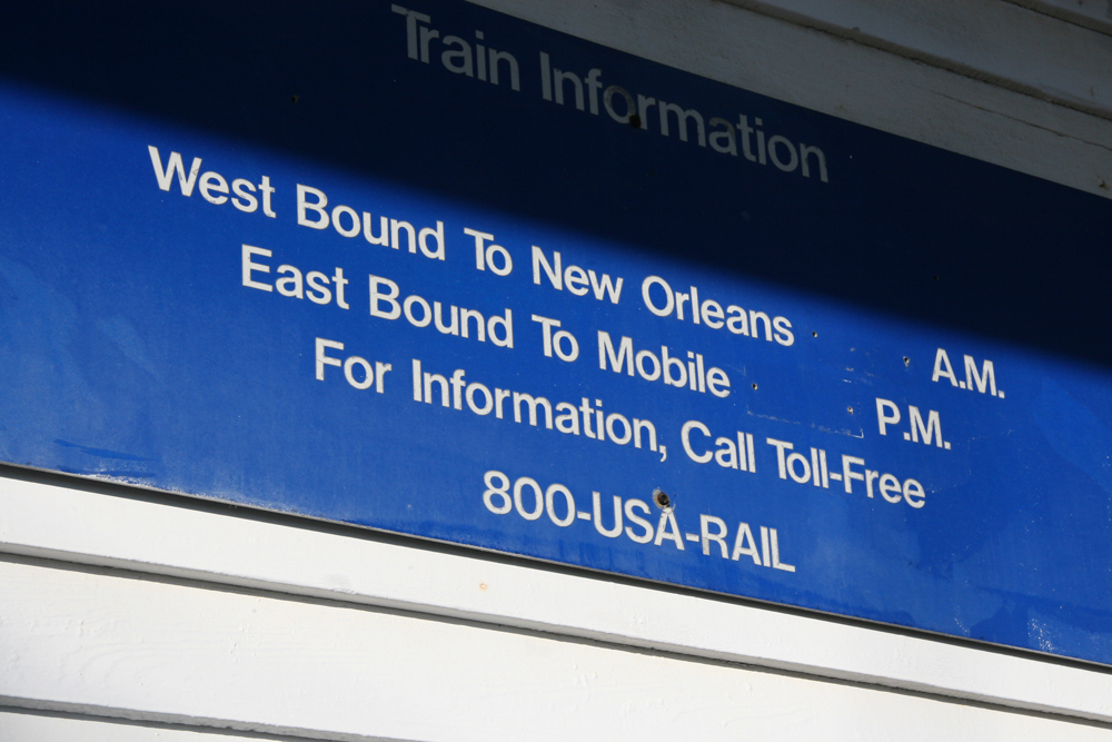Blue sign with white lettering, with some information removed