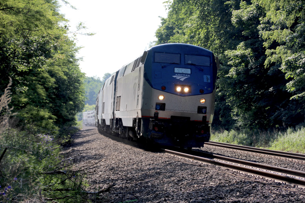 Amtrak long-distance passenger train rounds curve.