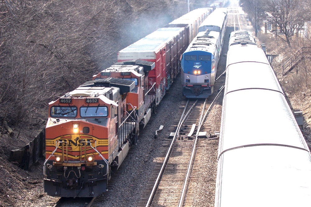 Three trains — one freight, two passengers — meet on triple-track main line.