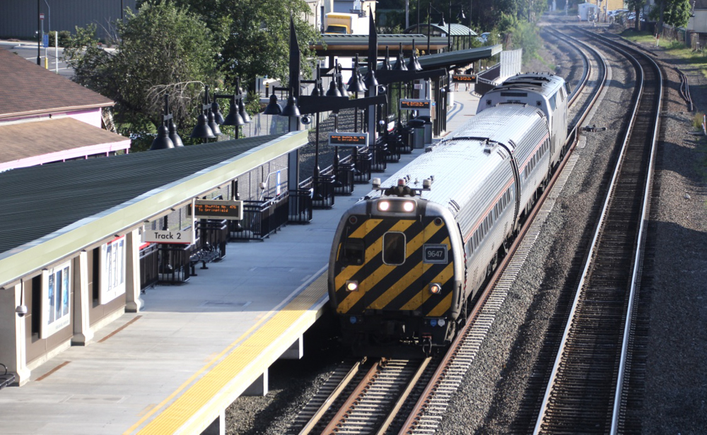 Cab car leads short passenger train past station