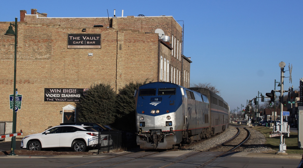 Train passes next to buildings in small town.