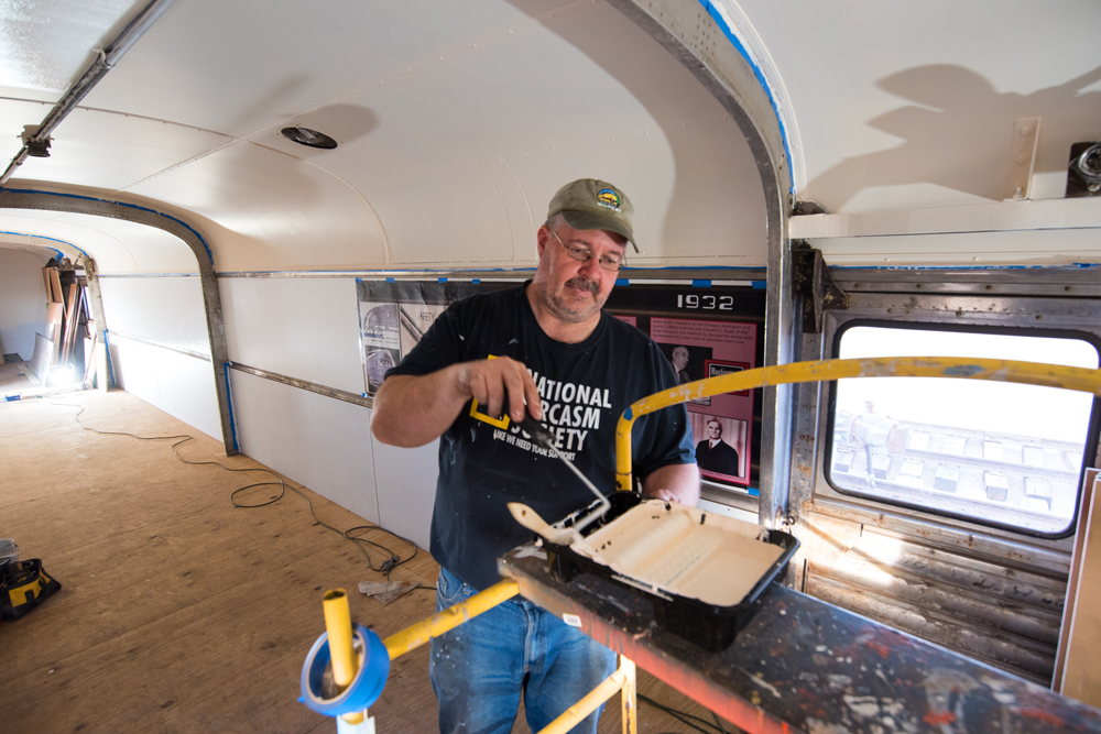 Man painting inside of passenger car