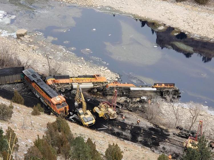 Derailed locomotives and cars in river