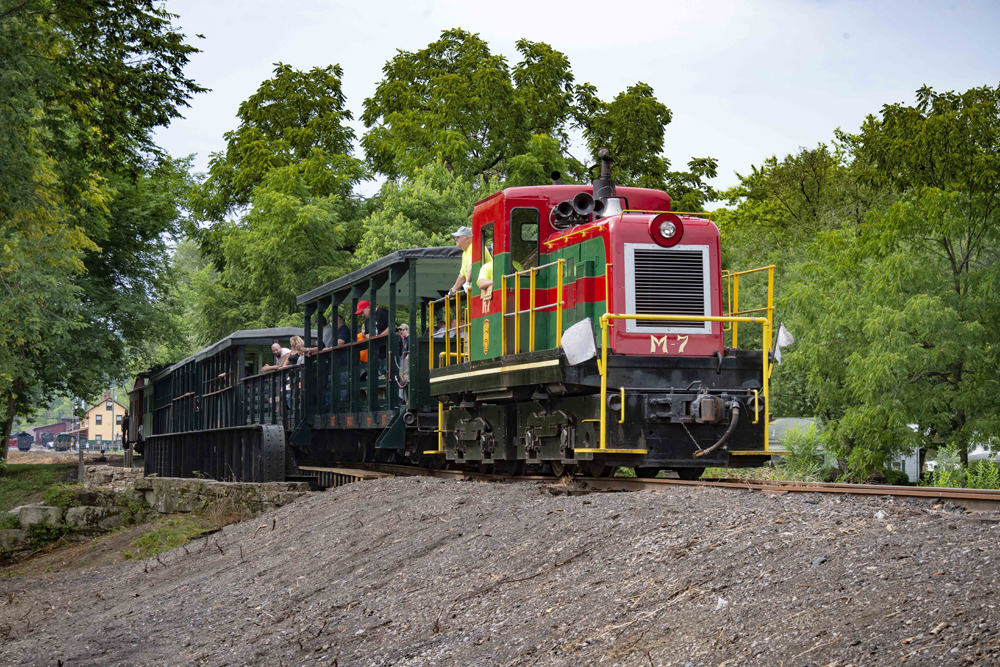 Red-and-green center-cab diesel purring cars of passengers