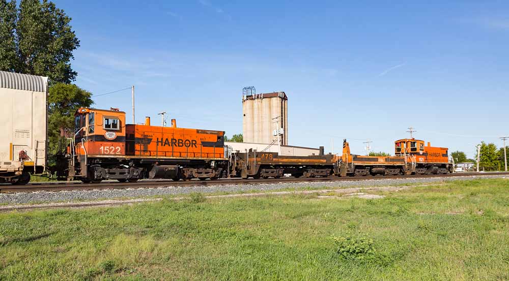 Two orange slugs operate with two orange diesel locomotives 