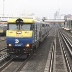 Blue and yellow diesel pulling commuter train