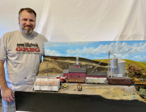 Gregory Baker, last year's adult individual winner, stands next to his layout.