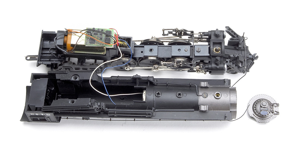 An HO scale steam locomotive with its body shell removed, exposing the motor and DCC decoder