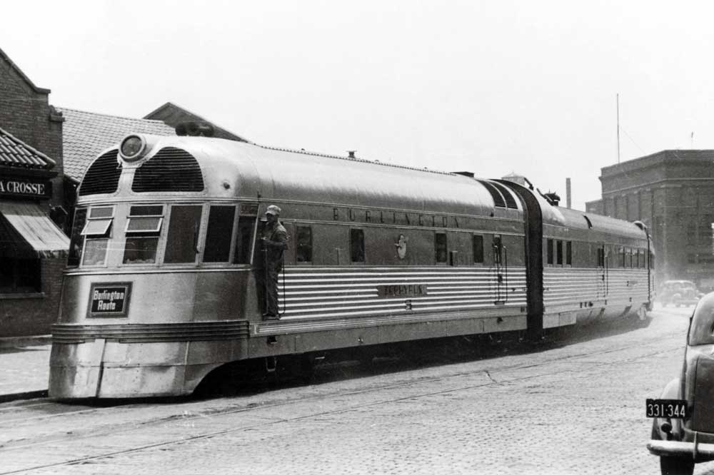 Shovel-nose streamlined diesel with passenger train in street