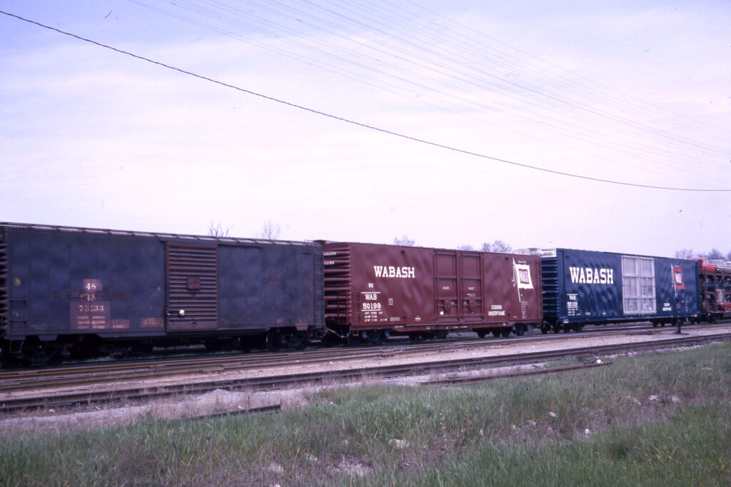 Large and small boxcars coupled together