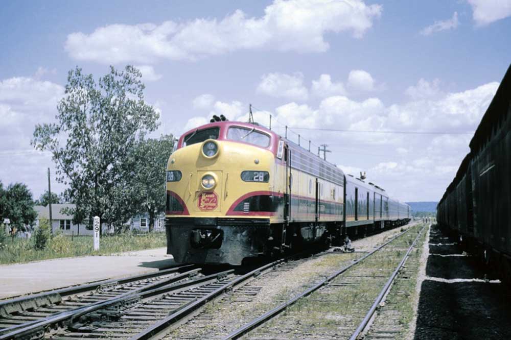 Black, red, and yellow diesel locomotive on passenger train