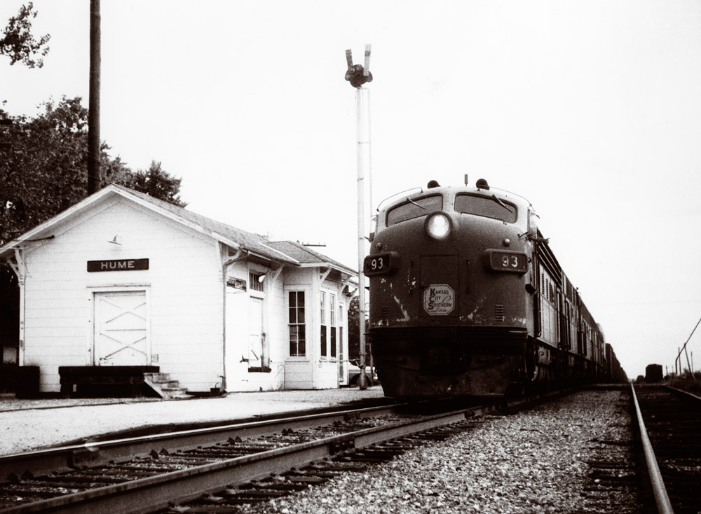 Streamlined diesel locomotive passing depot