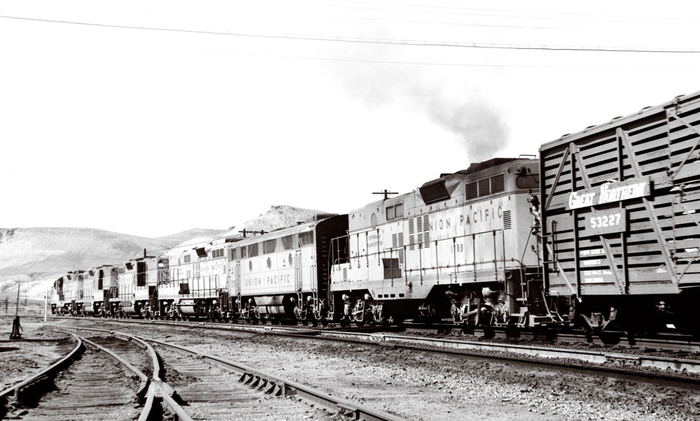 Five road-switcher and one streamlined diesel locomotives on freight train