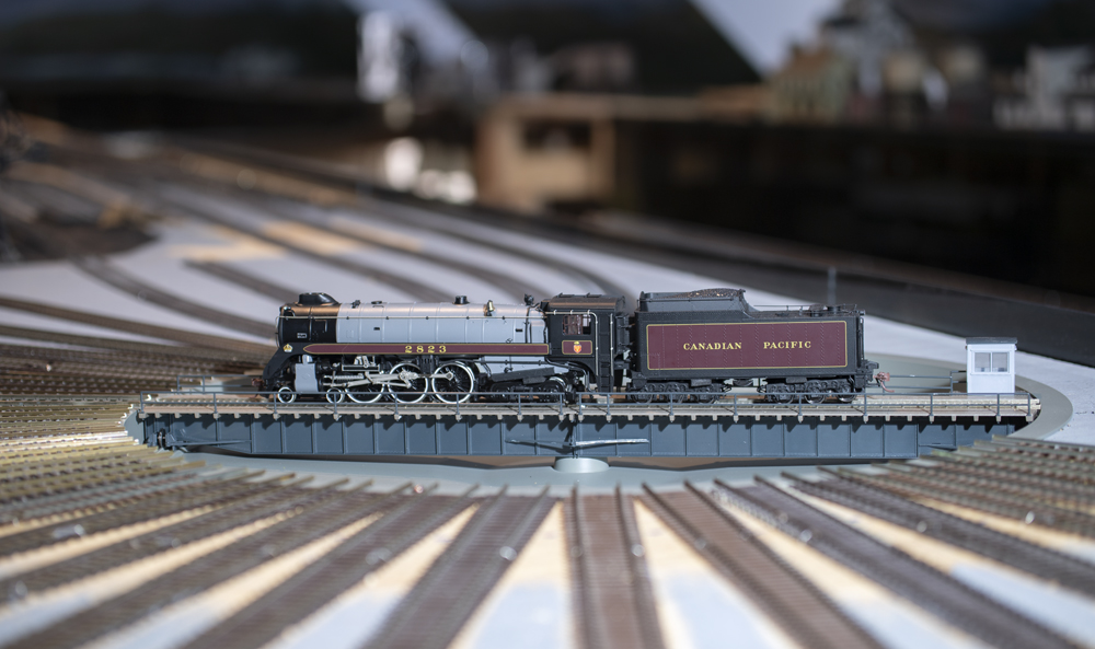 Canadian Pacific maroon and gray Royal Hudson sits on Walthers turntable in field of track