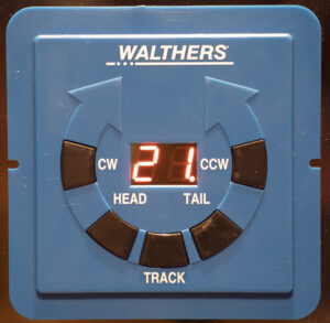 Blue Walthers controller box for turntable with five buttons arranged in a circle around an LED display showing the number 21