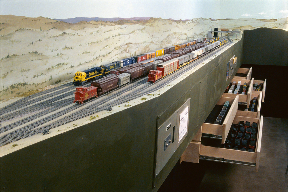 Two HO scale Nickel Plate Road steam locomotives meet at a rural grade crossing on Tony Koester’s HO scale model railroad.