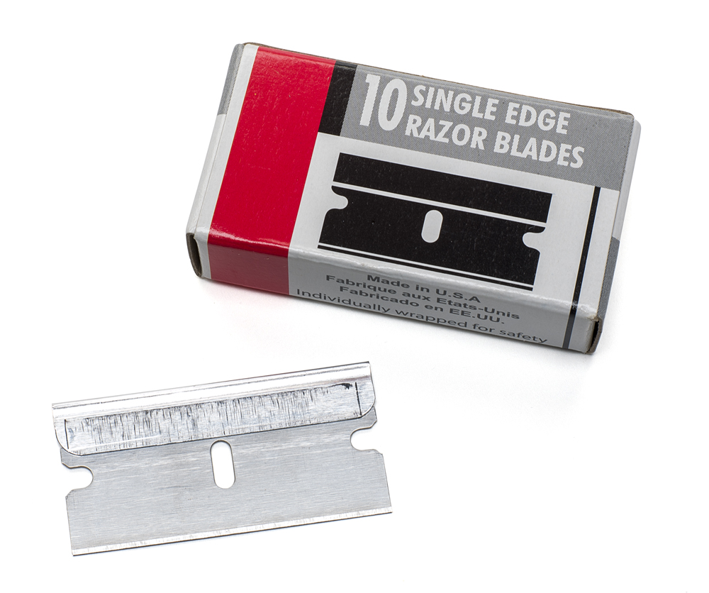 Pack of razor blade with a single razor blade sitting beside it
