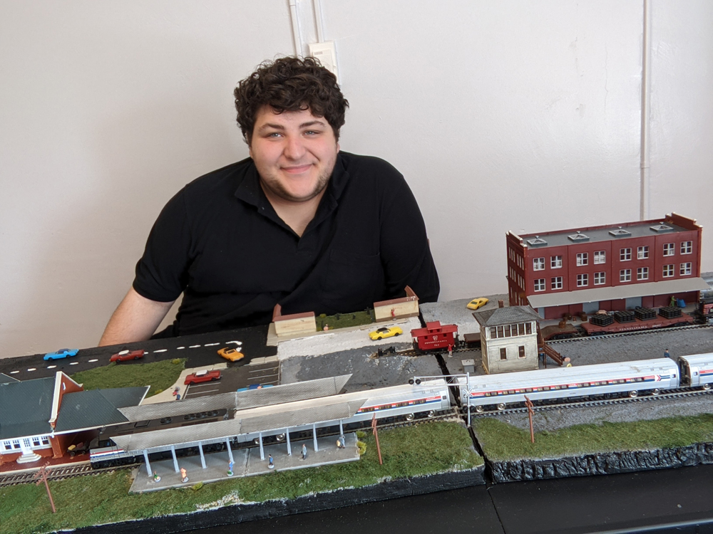 Matthew Mendolia sits posed behind his finished layout