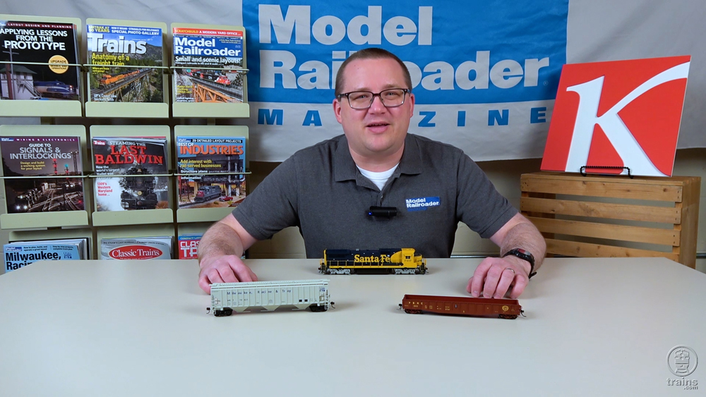 Cody Grivno sitting with locomotives on the table in front of him