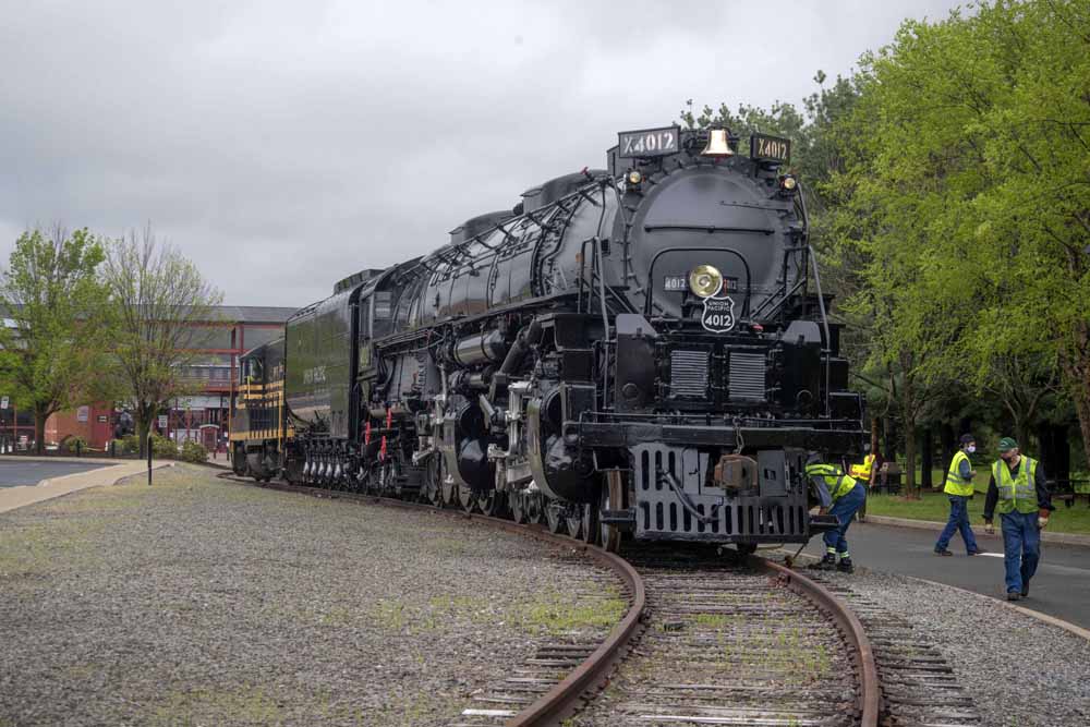 Steam locomotive on curve with people watching