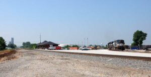 Freight train curves through town behind depot