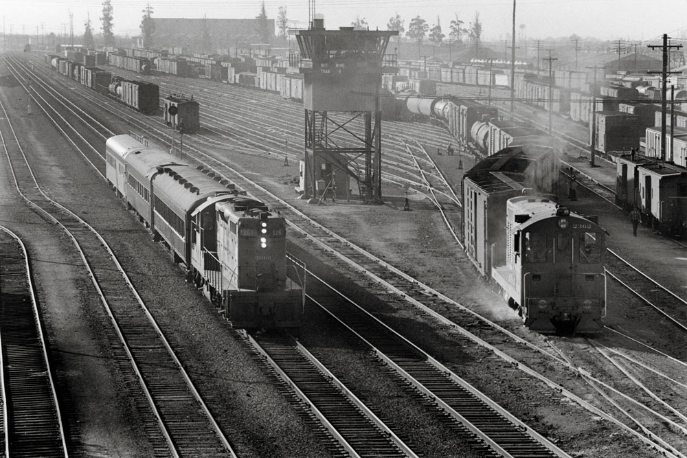 Locomotives and railcars in railroad yard in California in 1960s in a black and white image.