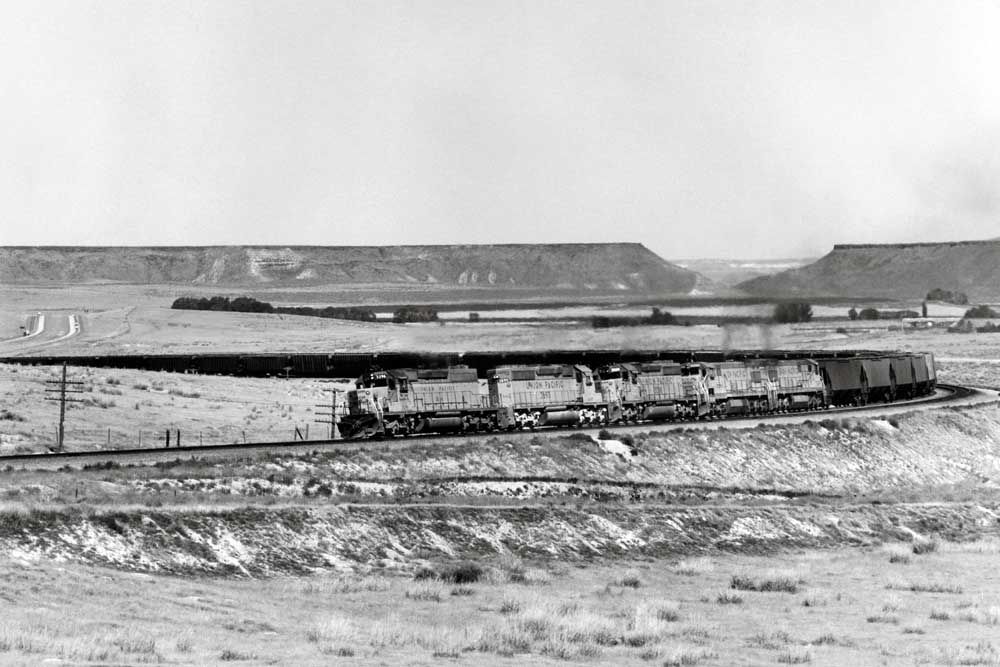 Five diesel locomotives on a hopper train in a sweeping S curve