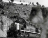 Black smoke follows diesel locomotives exiting tunnel