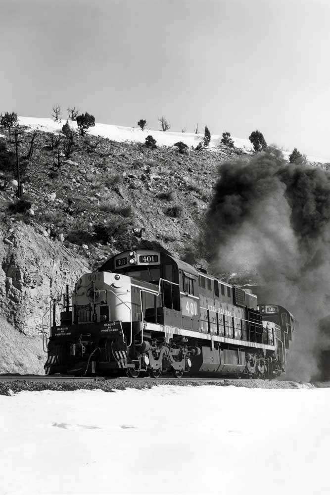 Black smoke follows diesel locomotives exiting tunnel