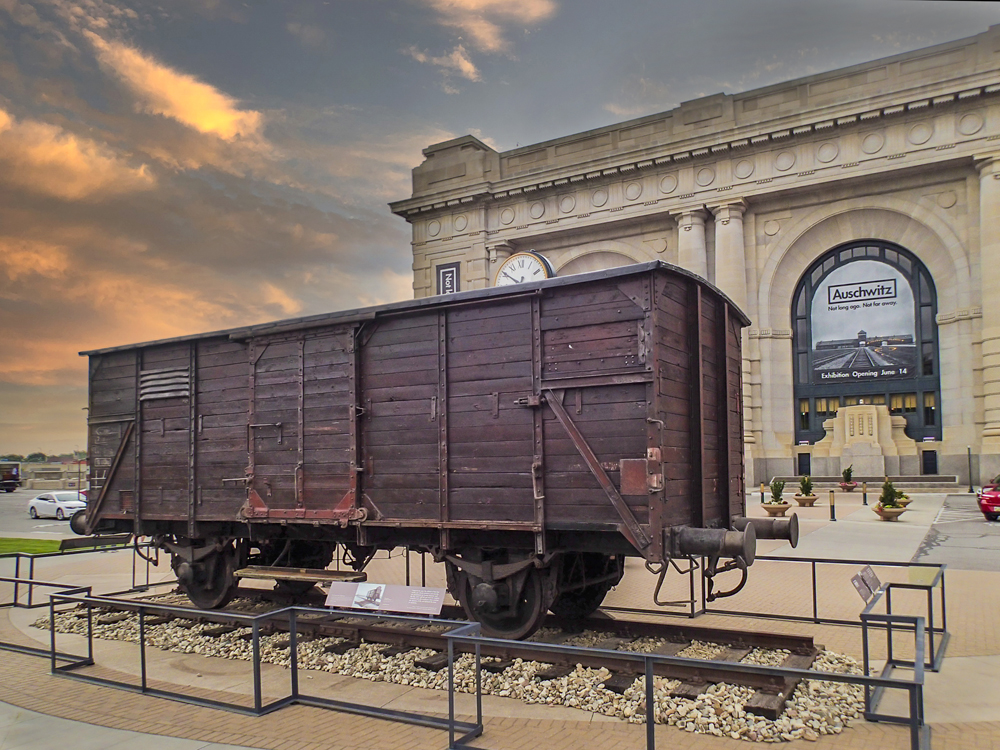 Four-wheeled European freight car on short piece of track outside railroad station