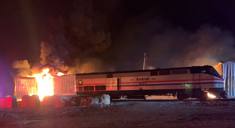 Amtrak locomotive with burning building in background