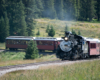 Steam passenger train rounds sharp curve to left