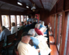 Inside of passenger car, with passengers in seats that face windows