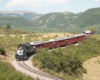 Train negotiates curve with mountains as backdrop