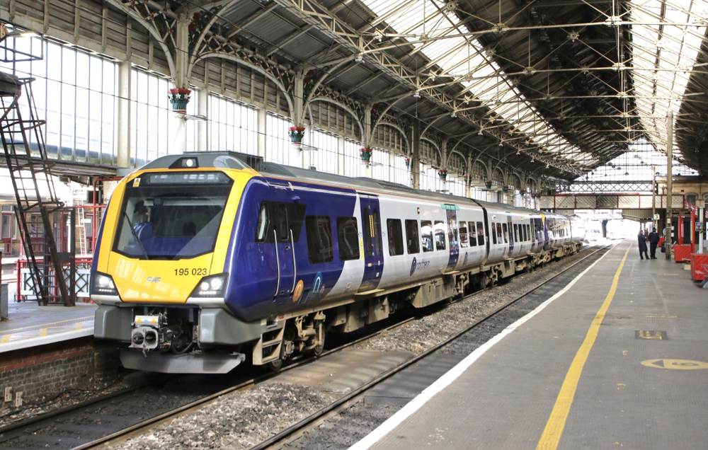 Blue, white, and yellow passenger train in station trainshed