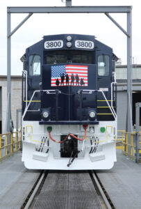 Front view of red, white, and dark blue locomotive