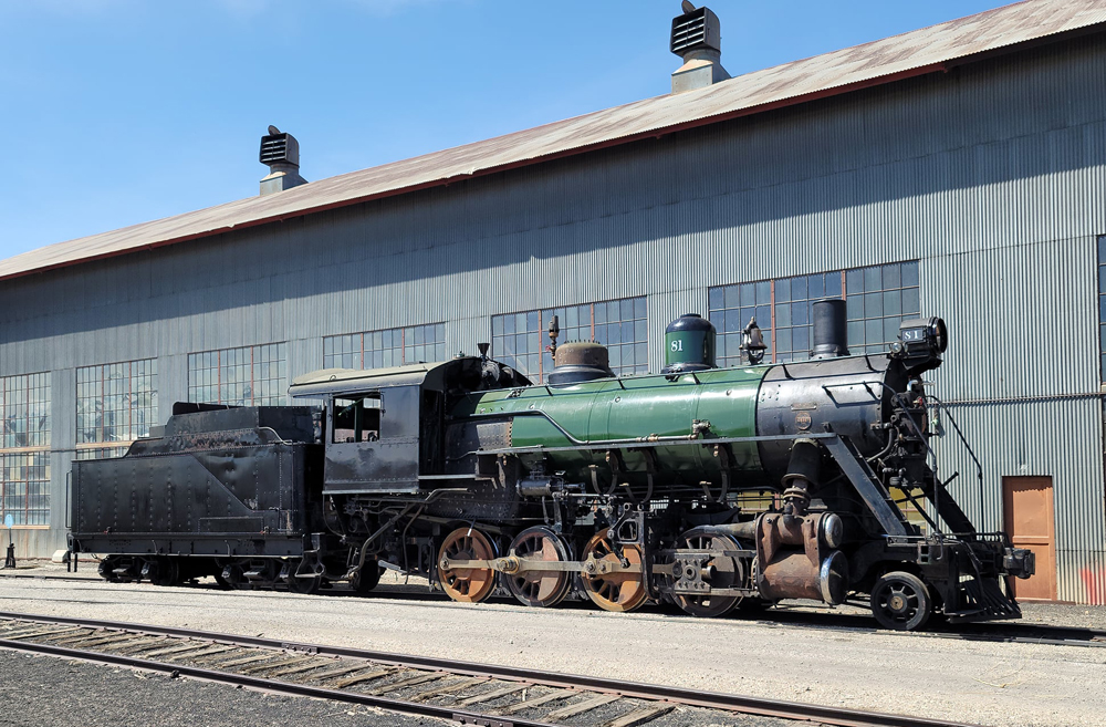 Steam engine outside shop building