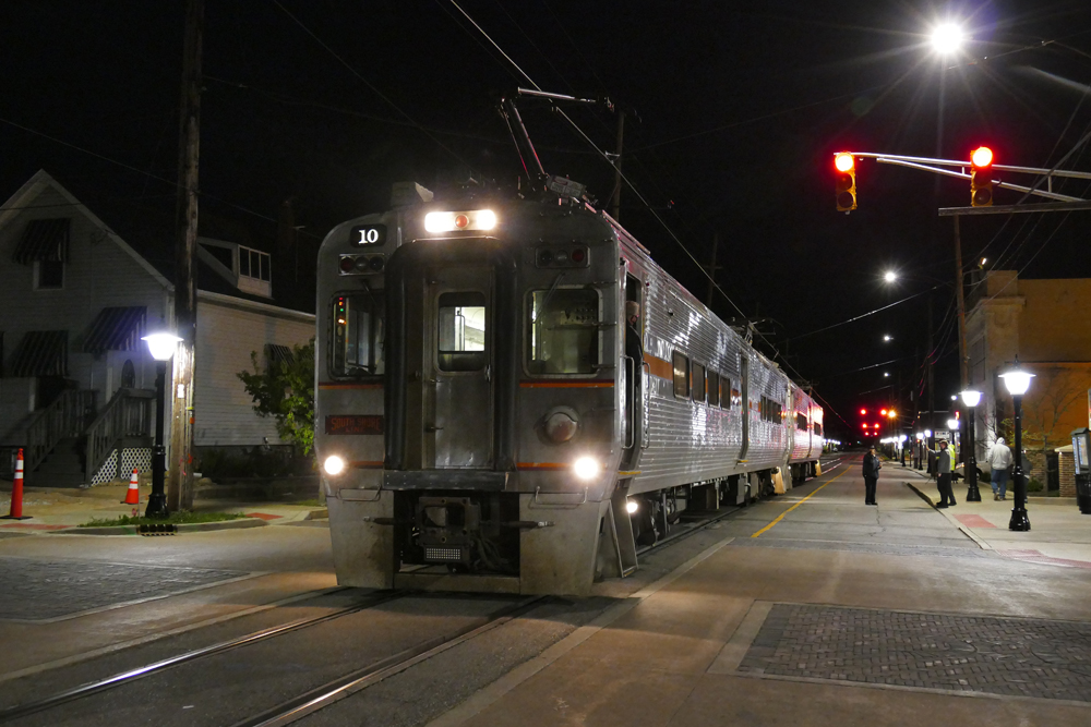 Commuter train stops in street at night
